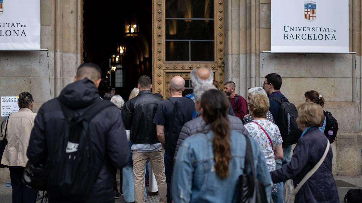 Varias personas acuden a ejercer su derecho a voto en la Universitat de Barcelona.