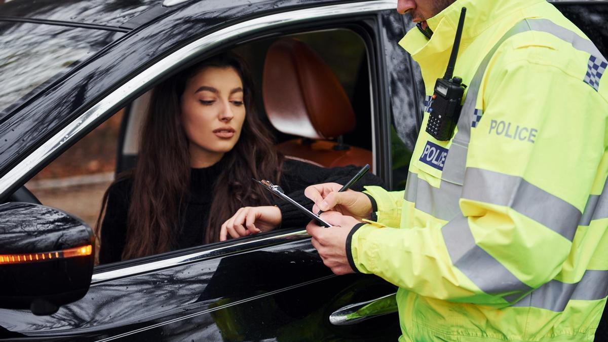 Agente en un control parando a un coche con los cristales tintados.