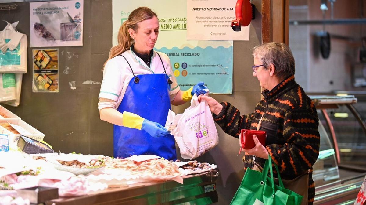 Una mujer recoge una compra de pescado en la Bretxa, este miércoles.