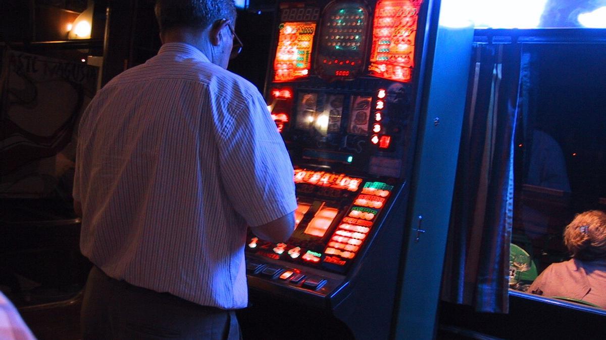Un hombre juega en una máquina tragaperras.