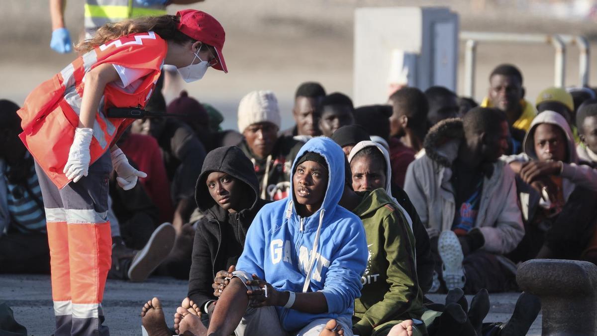 Personal de la Cruz Roja atiende a un grupo de migrantes llegado en un cayuco a Tenerife.