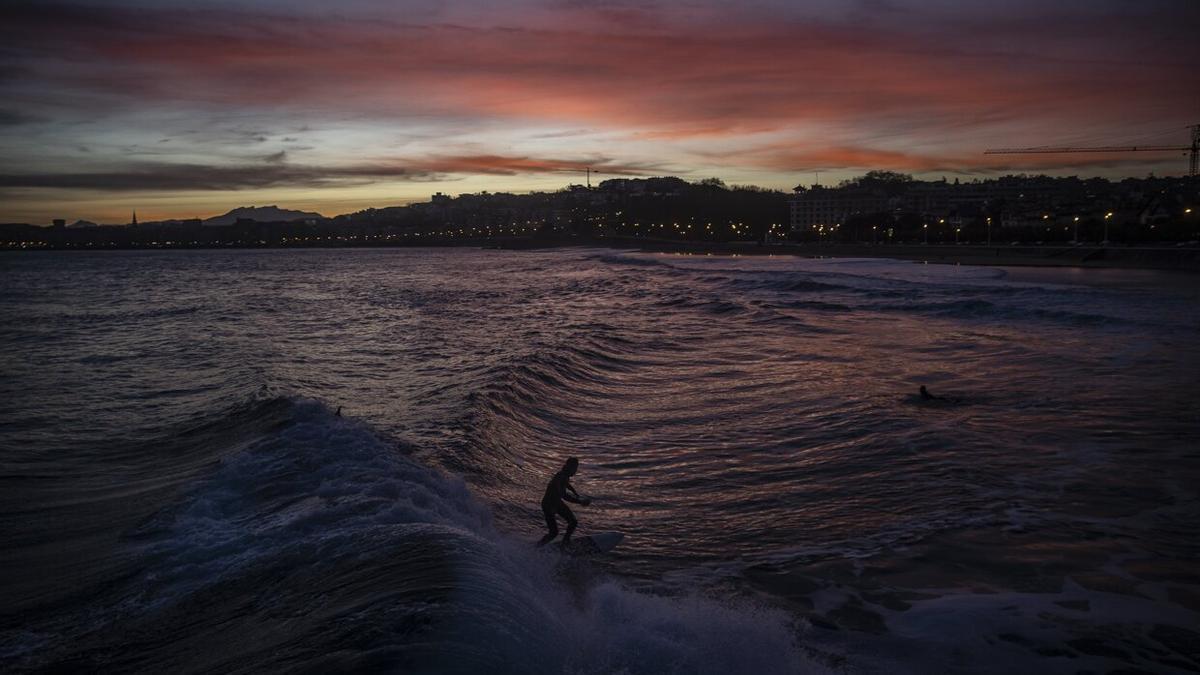 Varias personas hacen surf en la playa donostiarra de Ondarreta