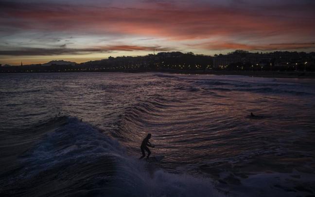 Varias personas hacen surf en la playa donostiarra de Ondarreta