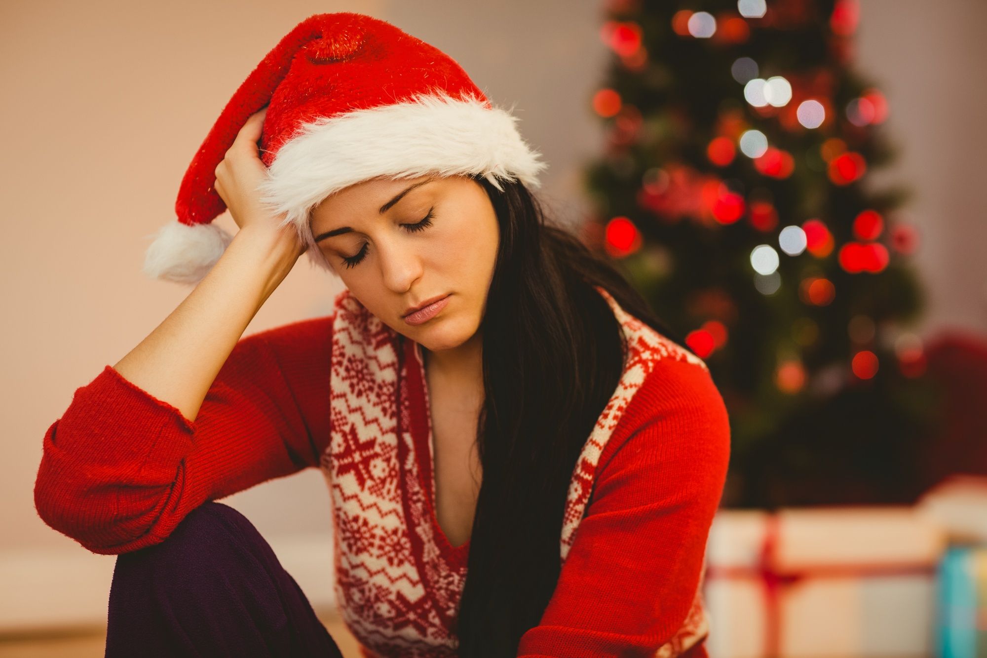 Una mujer no puede ocultar su tristeza en un entorno navideño.