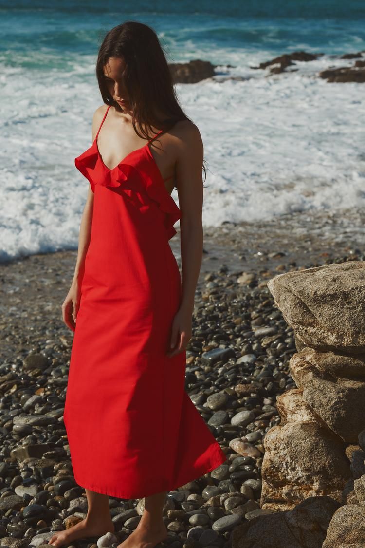 Una chica con un vestido de volantes en la playa.