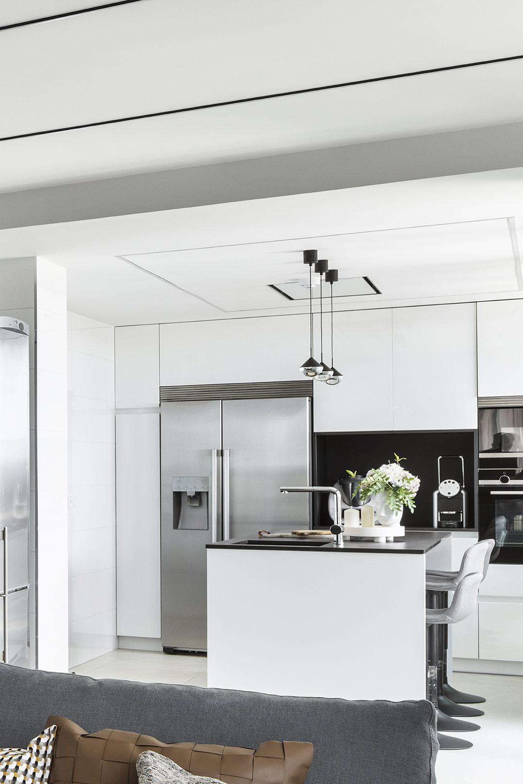 Cocina en blanco y negro con taburetes en estilo moderno.
