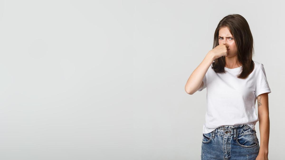 Una mujer se tapa la nariz molesta por el mal olor.
