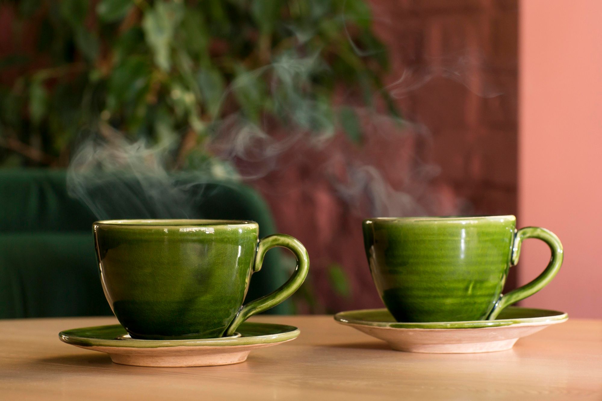 Dos humeantes tazas de café en color verde.