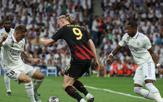 Erling Haaland (c) pelea un balón con Toni Kroos (i) y David Alaba. Erling Haaland (c) pelea un balón con Toni Kroos (i) y David Alaba.