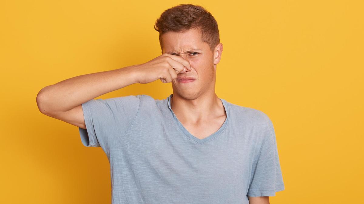 Un joven se tapa la nariz al percibir un mal olor.