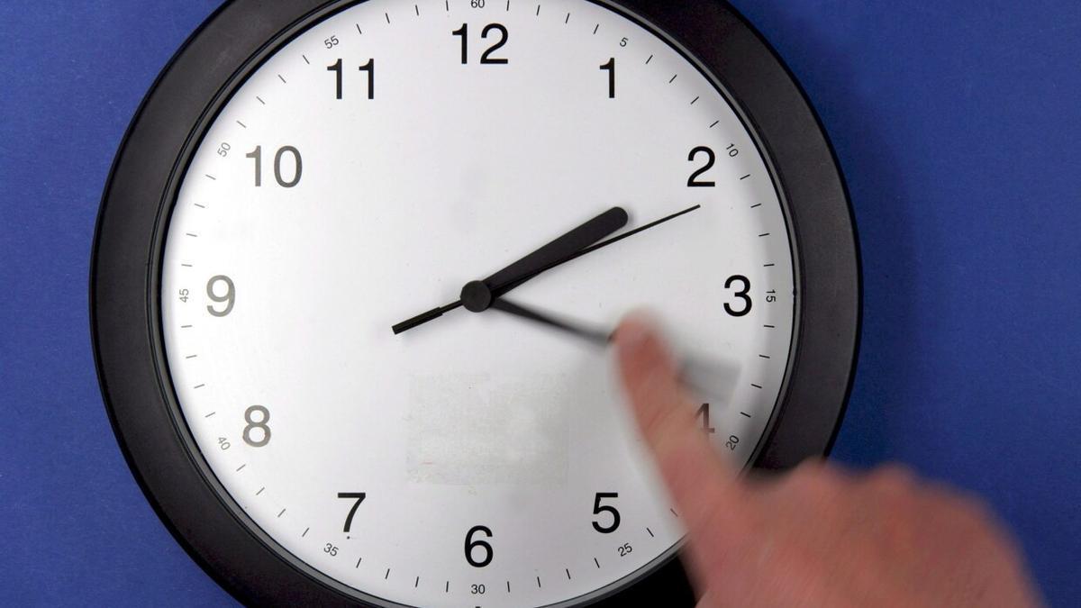 Una persona actualiza su reloj ante un cambio horario oficial.