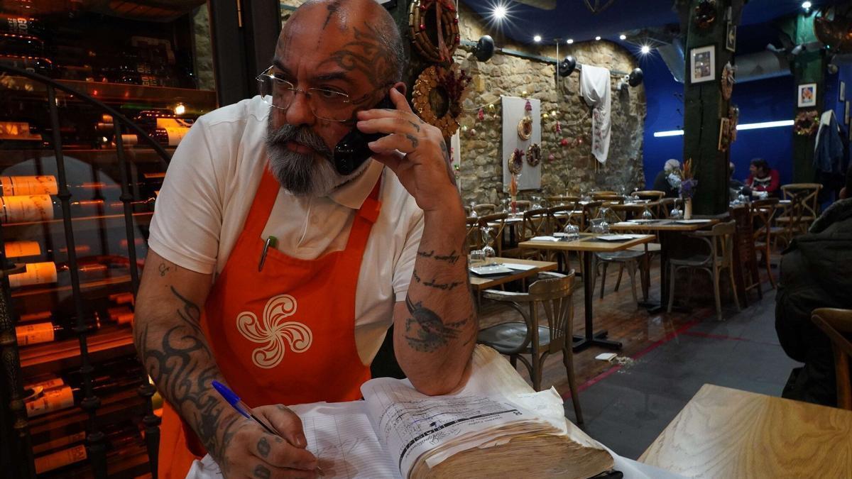 Trabajador de un local en Bilbao anotando reservas.