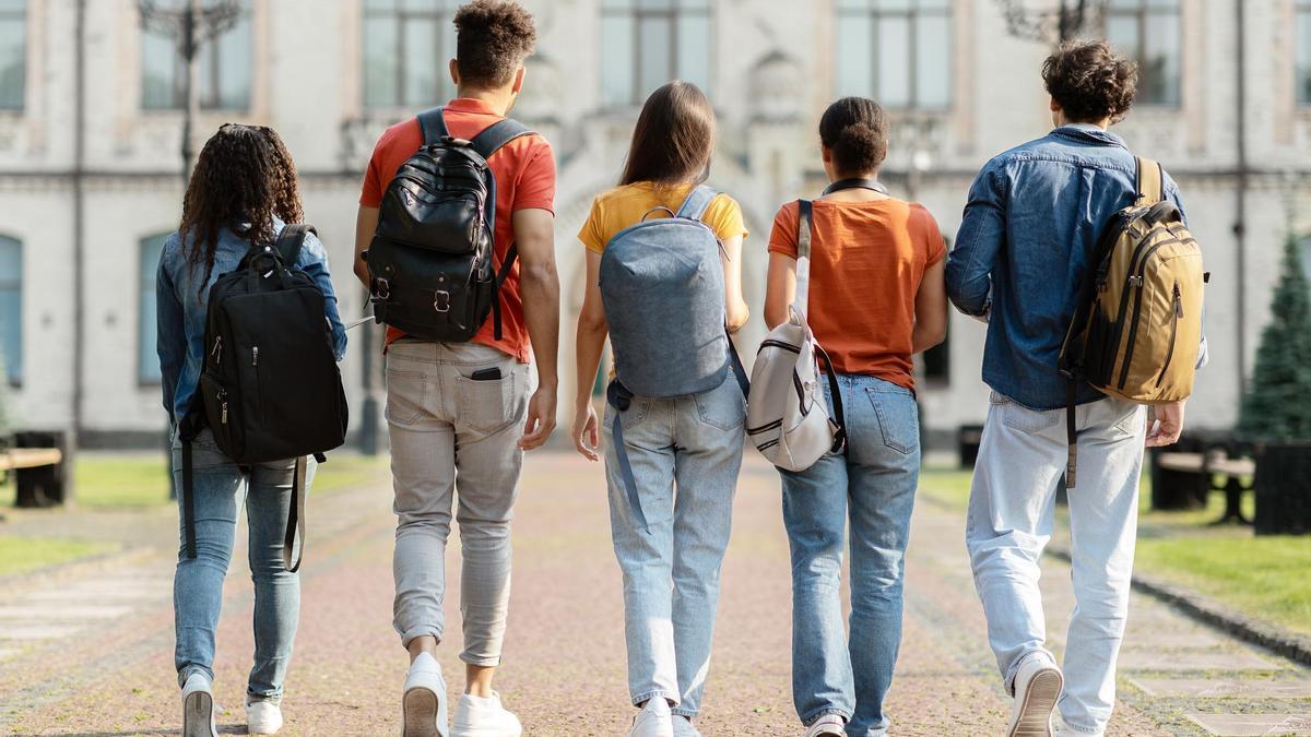 Un grupo de estudiantes se dirige a clase en un campus universitario.
