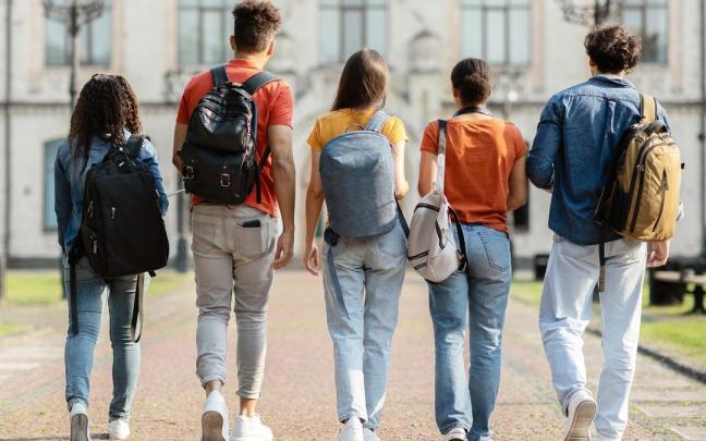 Un grupo de estudiantes se dirige a clase en un campus universitario.