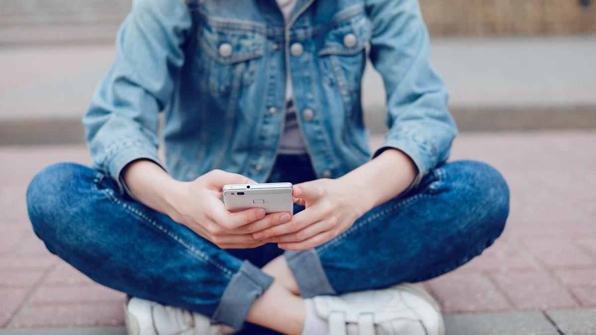Una adolescente utiliza un teléfono móvil.