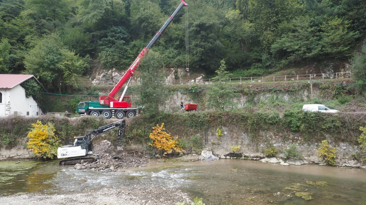 Una máquina retroexcavadora trabaja en el cauce del Urola en la retirada del azud situado a la altura del Balneario de Zestoa.