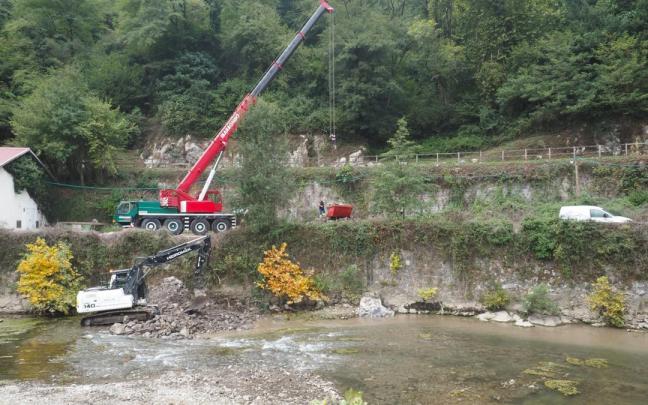 Una máquina retroexcavadora trabaja en el cauce del Urola en la retirada del azud situado a la altura del Balneario de Zestoa.