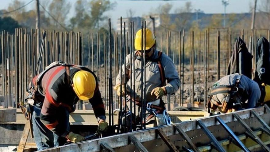 varios trabajadores de la construcción trabajando en una obra.