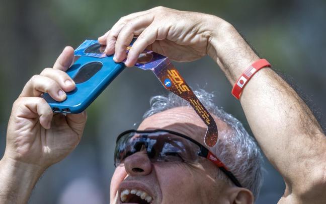 Hombre fotografía un eclipse solar.
