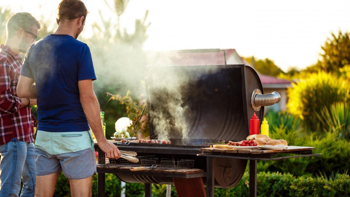 Dos jóvenes, haciendo una barbacoa.