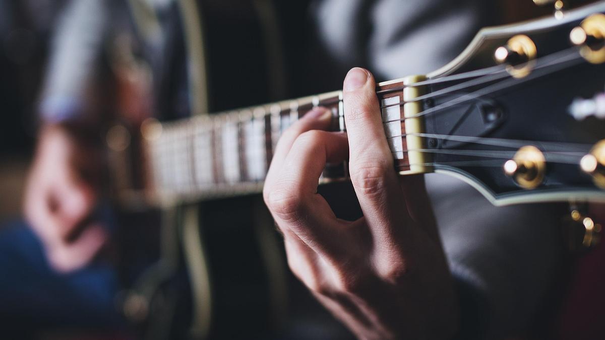 Una persona tocando la guitarra.