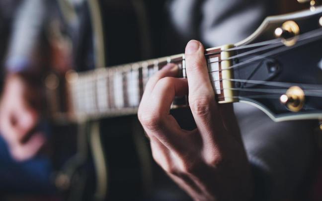 Una persona tocando la guitarra.
