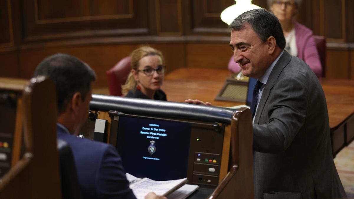 El presidente del Gobierno español en funciones, Pedro Sánchez, de espaldas, con el portavoz del PNV en el Congreso, Aitor Esteban