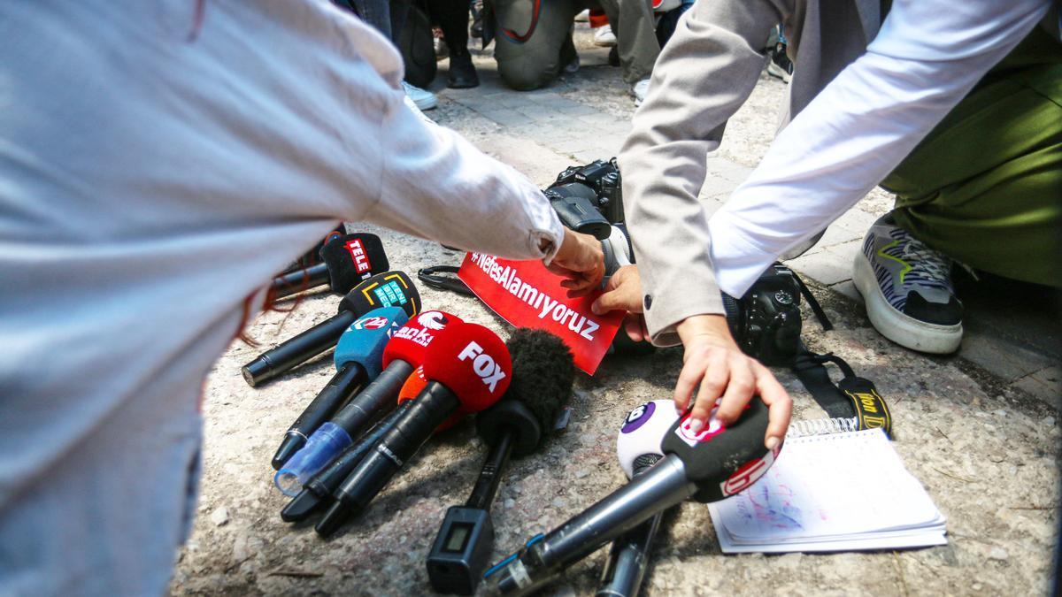 Varios periodistas protestan en Ankara depositando sus micrófonos y cámaras en el suelo.