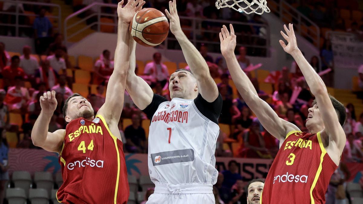Joel Parra y Sergio de Larrea pelean un rebote con el georgiano Giorgi Shermadini.