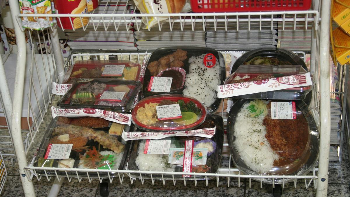 Un expositor con varias bandejas de comida preparada para llevar.