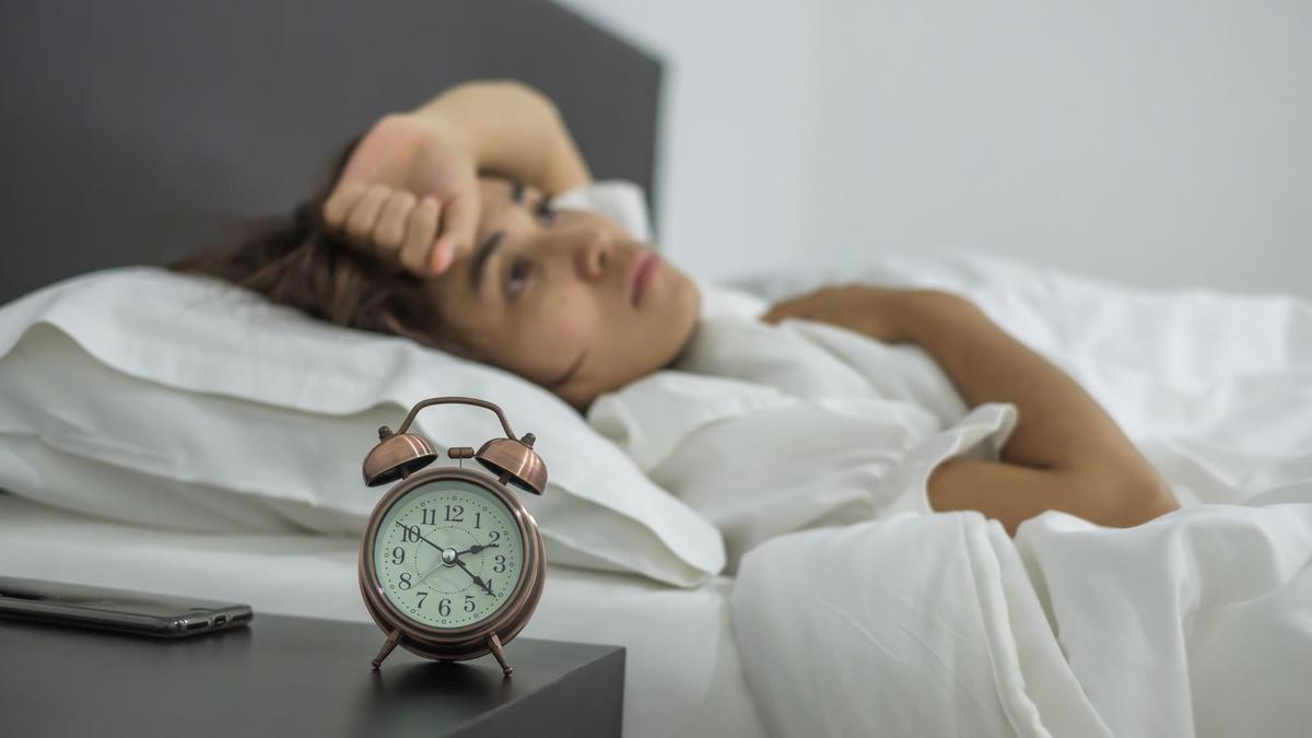 Una mujer permanece despierta en la cama.