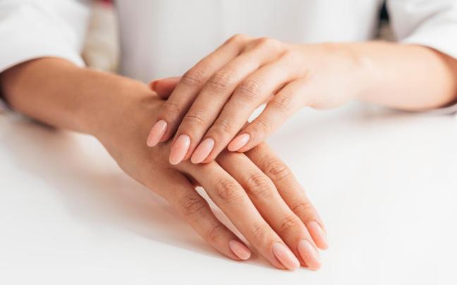Manicura en tono rosa palo brillante.