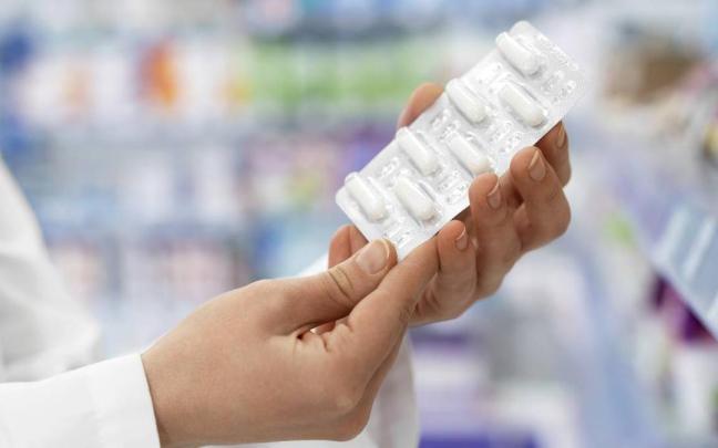 Un farmacéutico sostiene un blíster de pastillas.