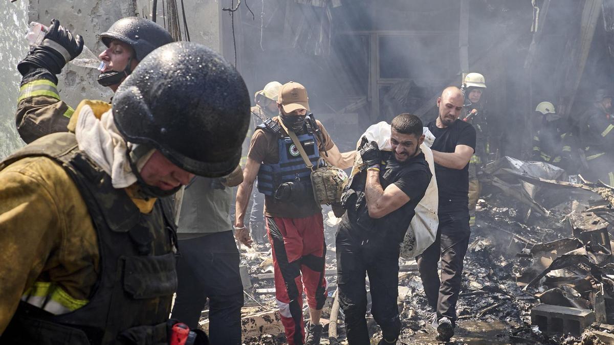 Miembros de equipos de rescate trasladan el cuerpo de una víctima de los escombros de una casa bombardeada en Járkov.