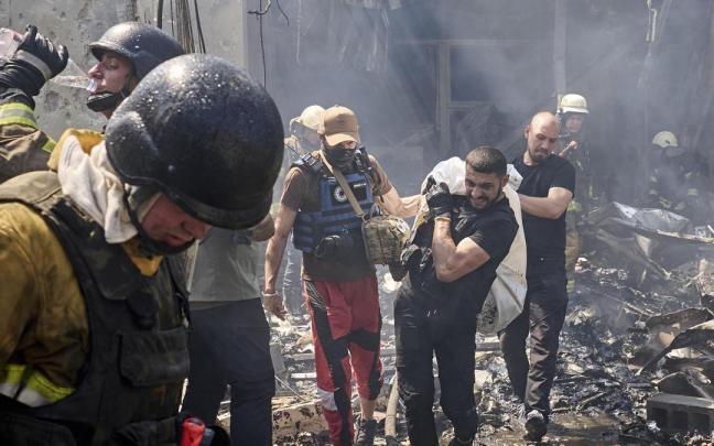 Miembros de equipos de rescate trasladan el cuerpo de una víctima de los escombros de una casa bombardeada en Járkov.