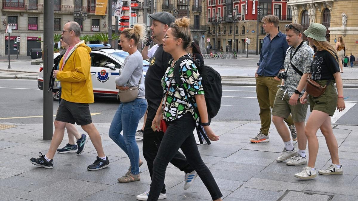 Varios turistas paseando ayer al mediodía en la capital vizcaina con un termómetro muy ajustado’para la época.