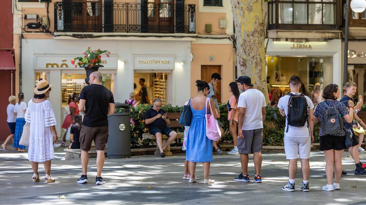 Varias personas pasean por Palma, Mallorca.