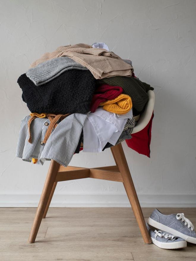 Prendas de ropa apiladas en una silla.