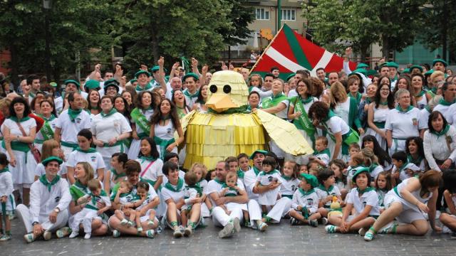 Integrantes de Dantza Lagunak, en su 50 aniversario, posando con un réplica gigante de su mascota el pato Ruper en la plaza Juan Urrutia