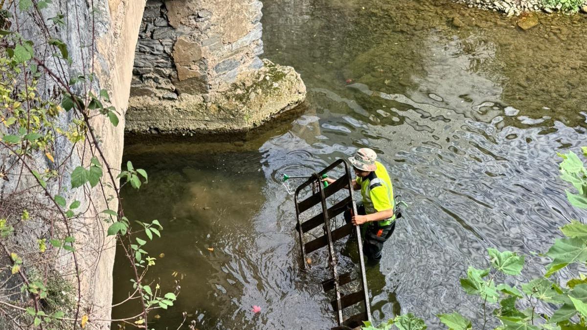 Un operario retira un somier del cauce del rio Urola.