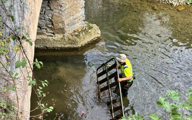 Un operario retira un somier del cauce del rio Urola.