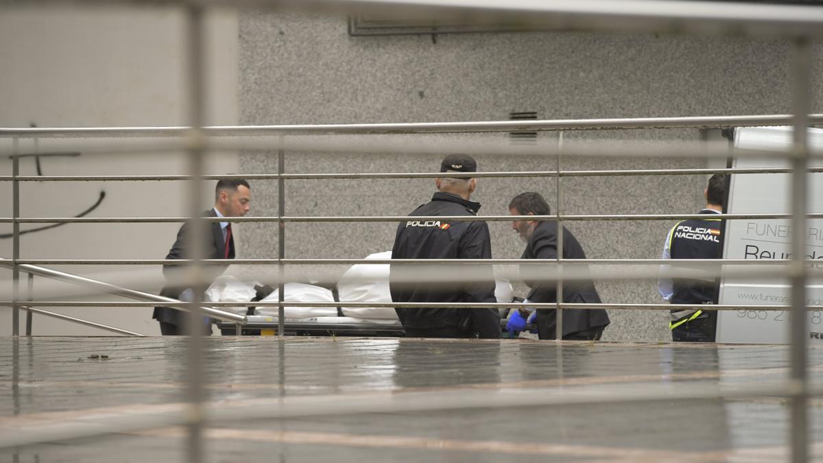 Operarios de una funeraria trasladan el cadáver de una de las niñas.