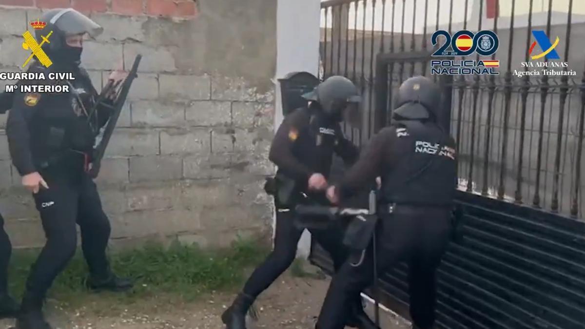 Los policías, golpeando la verja con un ariete.