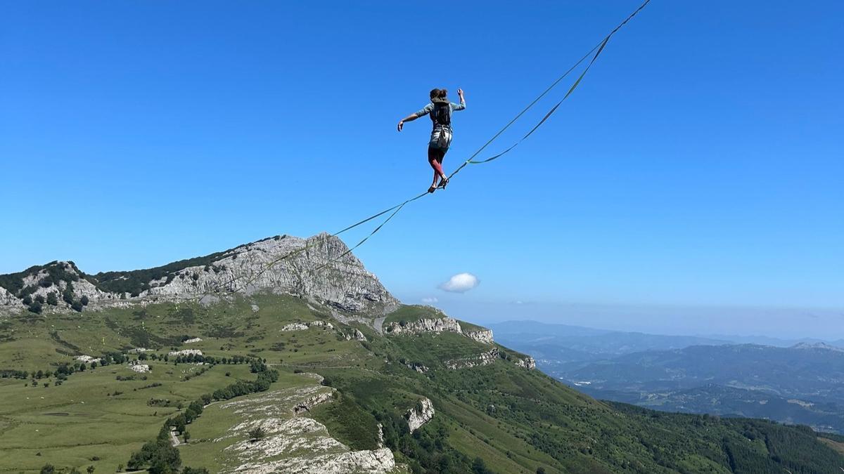 Uno de los integrantes de las asociaciones de slackline suspendido sobre la línea de récord montada en Gorbeia