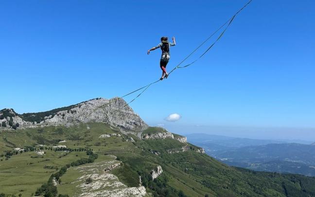 Uno de los integrantes de las asociaciones de slackline suspendido sobre la línea de récord montada en Gorbeia