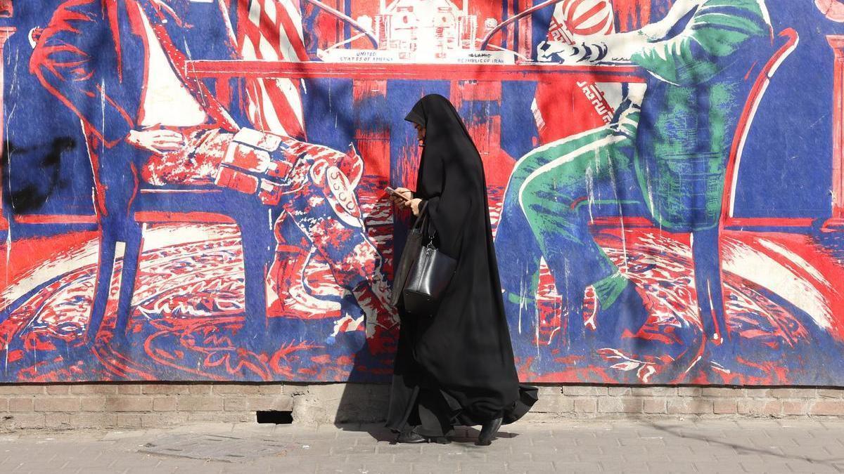 Una mujer iraní pasa junto a un mural antiestadounidense en Teherán.