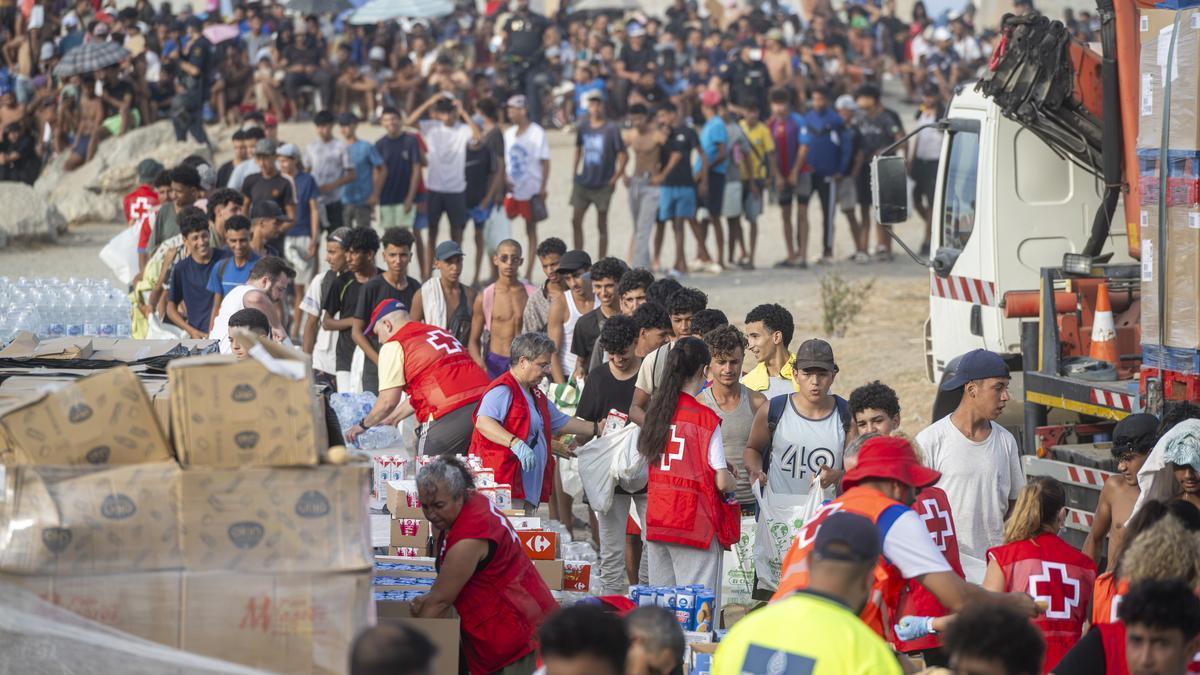Cruz Roja reparte comida en la playa de El Trampolín, en Ceuta.
