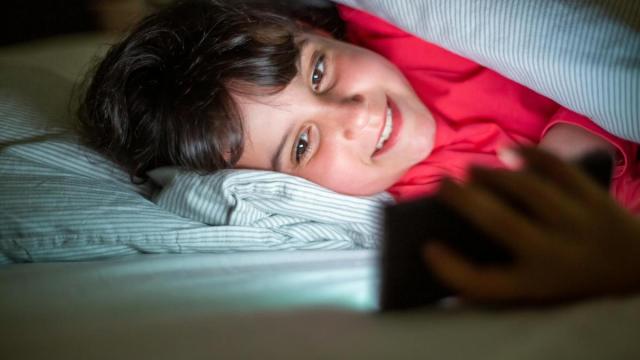 Un menor atiende a una pantalla por la noche