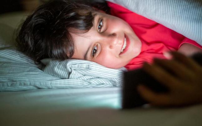 Un menor atiende a una pantalla por la noche