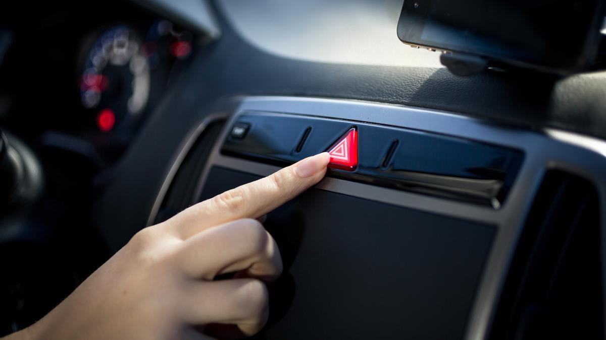 Una mujer presiona el botón que enciende las luces de emergencia.